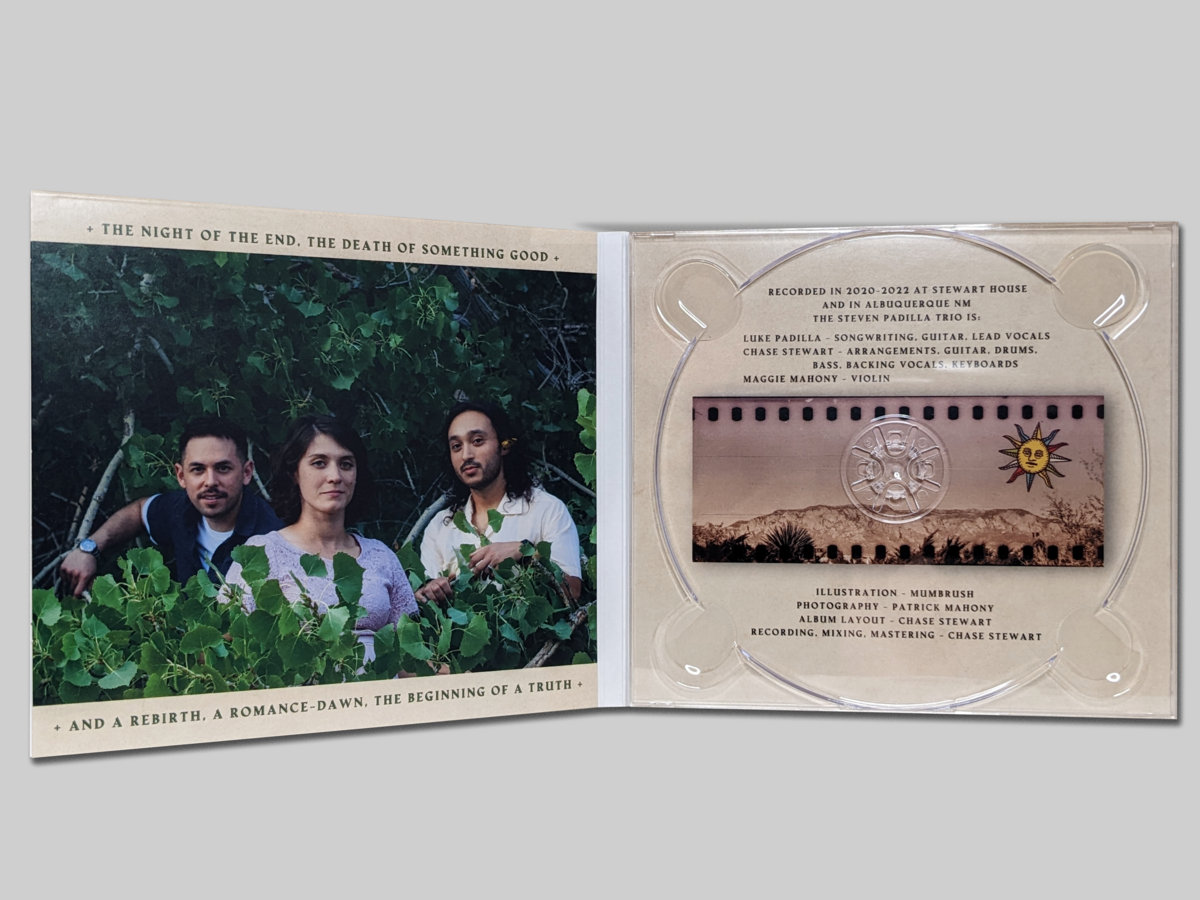 Digipak centerfold, left Side with a portrait of the band among leaves of a low tree, right side with a pink-tinted sprocket photo scan of the Sandia Mountain range and album credits